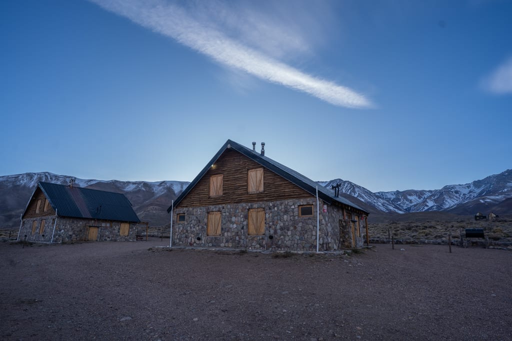 Cabañas del complejo al atardecer con la cordillera nevada.