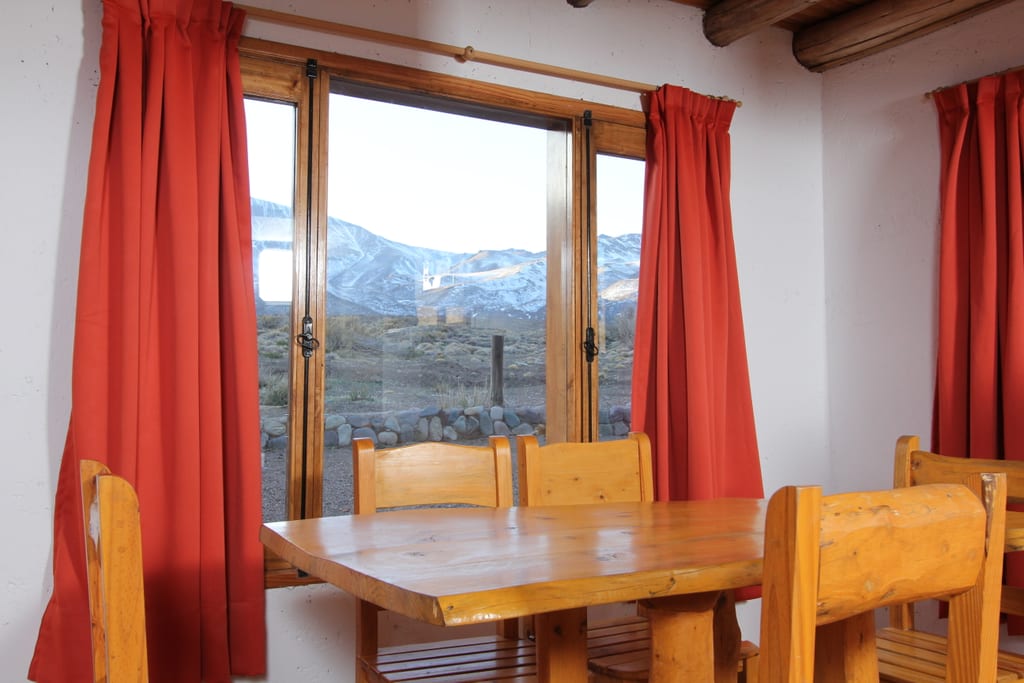 Comedor de la cabaña con vista a la cordillera.